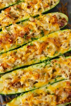 zucchini stuffed with cheese and other toppings on a baking sheet, ready to go into the oven