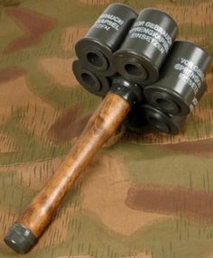 three black and wood rollers sitting on top of a camouflage cloth