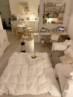 a living room filled with white furniture and lots of clutter on top of it