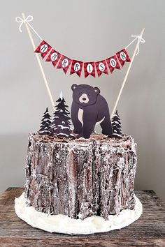 a cake that is on top of a wooden table with flags and trees in the background