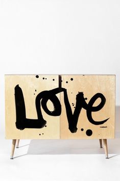 a wooden cabinet with the word love painted on it's front and side panels