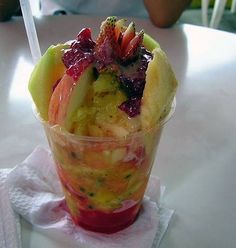 a glass filled with fruit on top of a table