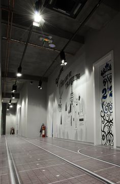 an empty room with white walls and tile flooring is lit by two spotlights