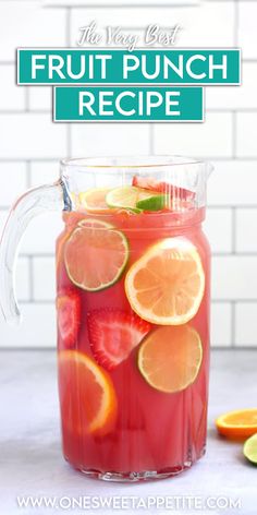 a pitcher filled with fruit punch on top of a table