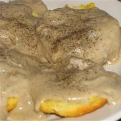 a white plate topped with meat covered in gravy