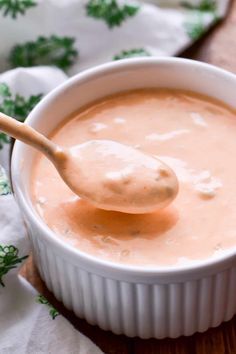 a wooden spoon in a white bowl filled with soup