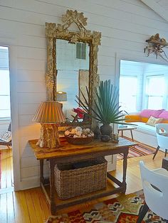 a living room filled with furniture and a large mirror on the wall over a table