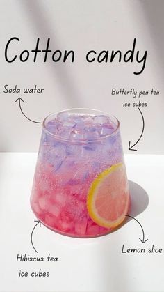 an image of cotton candy in a glass with ice cubes and lemon slices on it