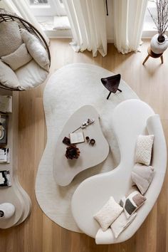 an aerial view of a living room with white furniture and accessories on the rugs