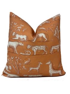 an orange pillow with white animals on it