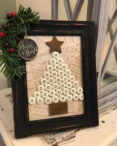 a christmas tree made out of buttons on top of a wooden frame with a star