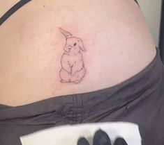 a woman's stomach with a small tattoo of a rabbit on the side of her belly