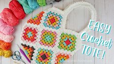 a crochet tote bag sitting on top of a table next to yarn and scissors