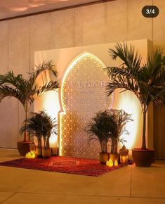 an entrance to a building with palm trees and candles on the ground in front of it