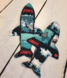 two pieces of fabric with jawss on them sitting on top of a wooden floor