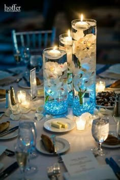 the centerpieces are filled with flowers and lit candles for an elegant table setting