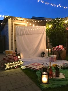 an outdoor patio decorated with lights and blankets