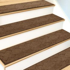 a set of brown carpeted stairs leading up to a white wall