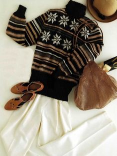 an old sweater, hat and shoes are laid out on a white sheet next to a pair of slippers