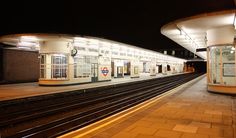 an empty train station at night with no people on the platform or in front of it