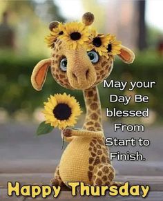 a stuffed giraffe with sunflowers on it's head and the words happy thursday