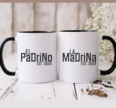 two black and white coffee mugs sitting next to each other