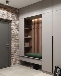 a room with a brick wall and some shelves on the side, next to a green bed