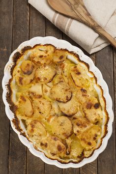 a dish with potatoes in it on a wooden table