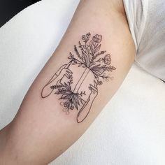 a woman's arm with a sunflower and clouds tattoo on the left forearm