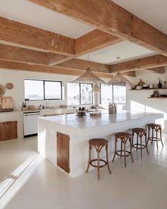 a large kitchen with an island in the middle and lots of stools around it