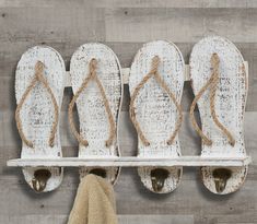 an old pair of slippers is hung on a wall with hooks and rope to hold them