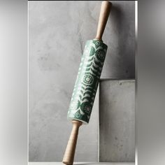 a baseball bat leaning against a wall with a green and white design on the handle