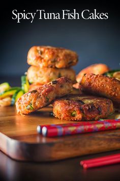 there are some fish cakes on the cutting board with chopsticks next to it