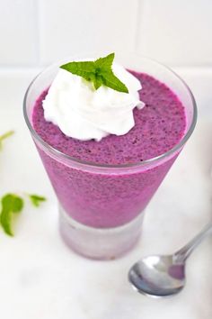 a close up of a dessert in a glass with whipped cream and mint on top