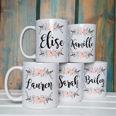 four personalized coffee mugs sitting on top of a white shelf next to a wooden wall