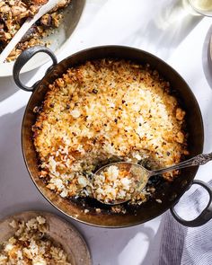 a casserole dish filled with rice and other food items on a white table