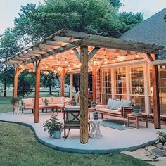 an outdoor patio covered in lights and furniture