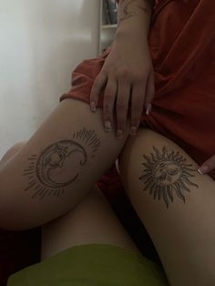 a woman with sun and moon tattoos on her legs, sitting in front of a mirror