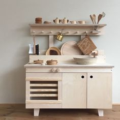 a kitchen with wooden cabinets and shelves filled with pots, pans and utensils