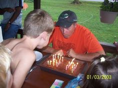 a man blowing out candles on a cake