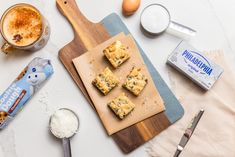 some food is laying out on a cutting board next to an egg and milk carton