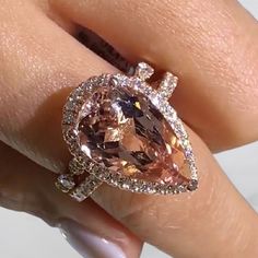 a woman's hand holding an engagement ring with a large brown diamond in the center