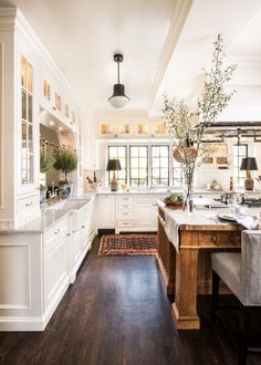 a large kitchen with white cabinets and wood floors