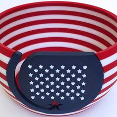 a red, white and blue striped bowl with stars on the side in front of an american flag pattern