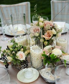 a table topped with vases filled with flowers and pearls