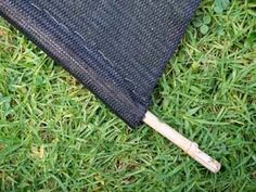 an open black umbrella laying on top of green grass