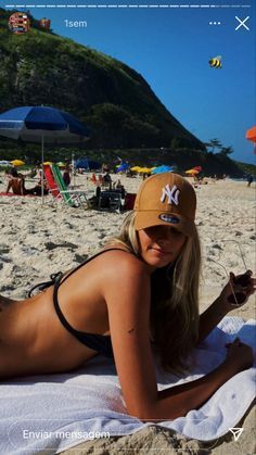 a woman laying on top of a sandy beach