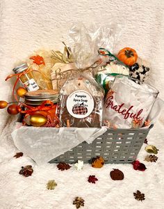 a basket filled with food sitting on top of a white blanket next to other items