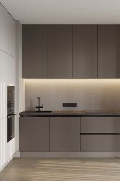 a modern kitchen with wooden floors and gray cabinetry is illuminated by recessed lighting