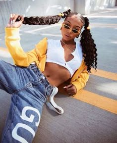 a woman sitting on the ground with her hair in a ponytail